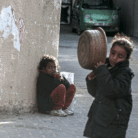 PALESTINIAN CHILDREN TRY TO GET SOME FOOD FROM ONE OF THE CHARITABLE HOSPICES IN DEIR AL-BALAH IN THE CENTRAL GAZA STRIP. (PHOTO: OMAR ASHTAWY/APA IMAGES)